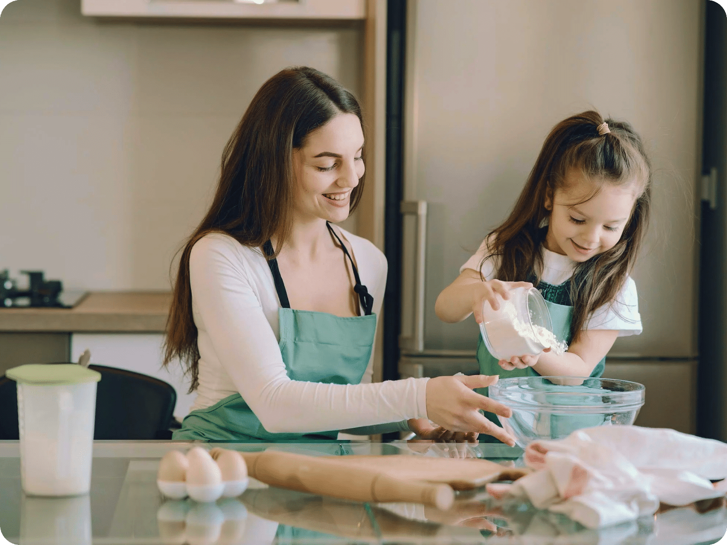 Mother and daughter mixing ingredients smiling