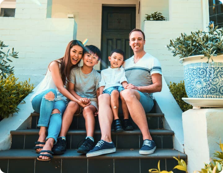 Family of four taking a portrait while sitting in the front porch