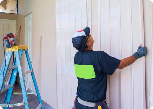 Man placing panels against wall carefully against a wall